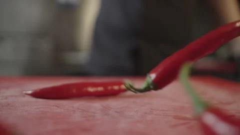 Close-up of chili peppers falling on a board in a restaurant kitchen Stock Footage 238381673