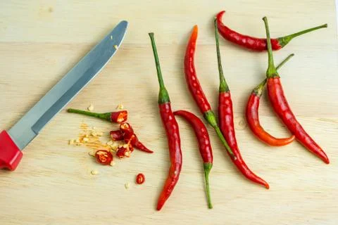 Close-up of chilli and red knives on a wooden floor, meat, fresh food ingredi Stock Photos
