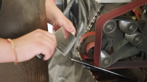 Close-up of a Chinese cleaver knife being sharpened on a grinding machine in Stock-Footage 333016582