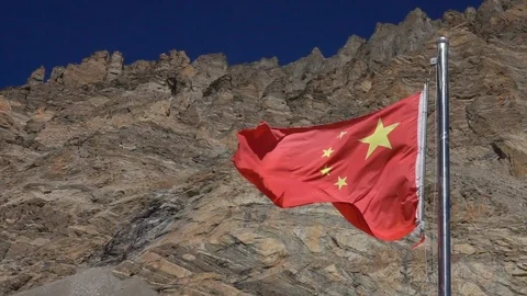 CLOSE UP: Chinese flag waves under the rocky mountain range in sunny Himalaya. Stock Footage 112983837