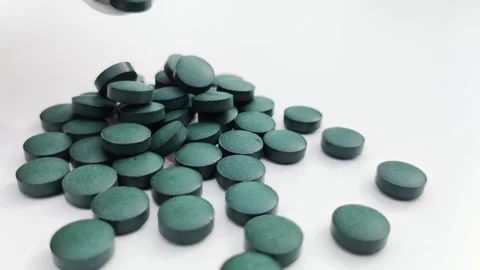 Close up chlorophyll spirulina tablet in slow motion falling, healthy detox supl Vidéo 241224576