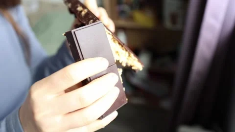 Close-up of a chocolate bar with crunchy nut and fruit filling creamy layers bre Stock Footage 306596780