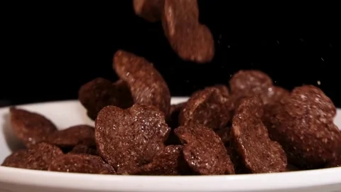 Close Up of Chocolate Cereal Flakes Falling into White Bowl Vidéo 325828268
