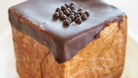Close Up Of a CHOCOLATE covered square CHOUX Pastry Dessert, UK Stock Footage 240236270
