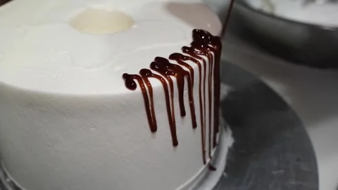 Close-up of Chocolate Ganache Drizzling Down a White Frosted Cake Stock Footage 331777585