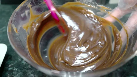 Close up of chocolate paste is being mixed in glass bowl on the kitchen. Stock Footage 86422644