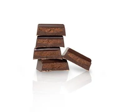 Close up of chocolate pieces stack and chocolate syrup on white background Stock Photos