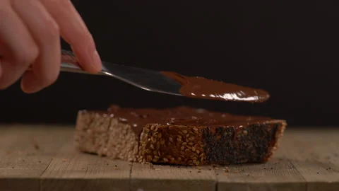 Close Up of Chocolate Spreading on Multi Grain Loaf Of Bread with Seeds Video stock 130214149