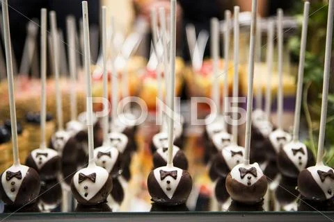 Close-Up Of Chocolate Tuxedo Lollipops On Dessert Table