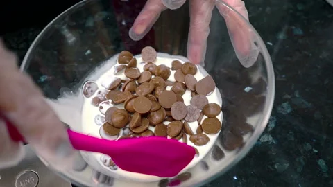 Close up of chokolate pieces being mixed with milk in glass bowl. Stock Footage 86422375