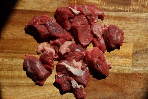 Close up of choped red beef or goulash on a wooden cutting board Foto stock