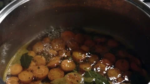 Close-up of chopped carrots boiling in circles in a saucepan. Stock Footage 220767572