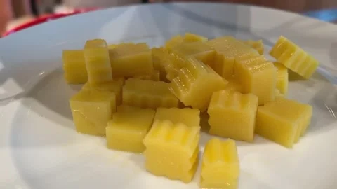Close-up of chopped cheddar cheese on a white plate Stock-Footage 312094936