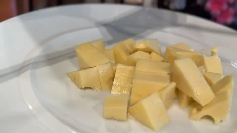 Close-up of chopped Emmental cheese on a white plate Stock Footage 312094943