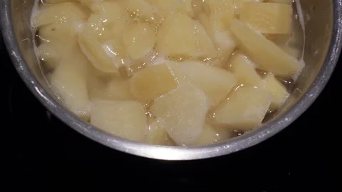 Close up chopped potatoes are boiled in a pan on an electric stove. 4k. 4k video Stock Footage 114703787