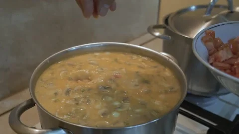 Close-up of chopped tomatoes pouring into tom yum soup. Video stock 169960344