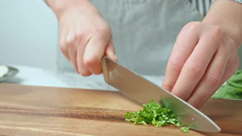 Close-up of chopping and sorting basil leaves on a cutting board in 4K. Stock Footage 142823257