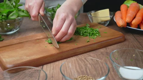 Close-up of chopping Basil Leaves with a chef knife on a cutting board in 4K. Stock Footage 145105585