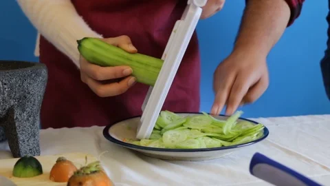 Close up of chopping cucumber with mandolin slicer Stock-Footage 124664310