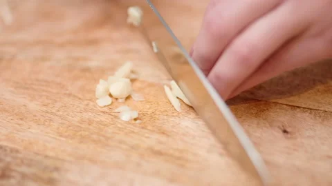 Close-up chopping garlic with a chef knife in 4K. Stock Footage 138302830
