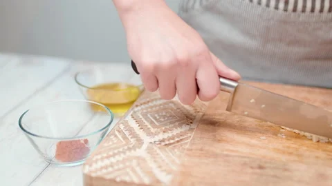 Close-up chopping garlic with a chef knife in 4K. Stock Footage 138302872