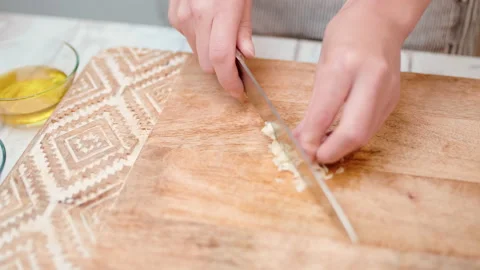 Close-up chopping garlic with a chef knife in 4K. Stock Footage 138302989
