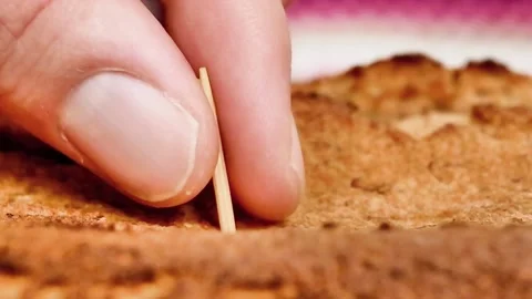 Close up of a chopstick sample on a freshly baked cake Stock Footage 218108869