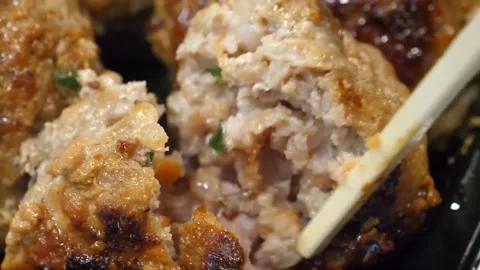 Close-up of Chopsticks Breaking Open a Crispy, Pan-Fried Meatball Video stock 343587352