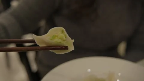 Close-Up of Chopsticks Holding Cut Dumpling with Vegetable Filling in Beijing Stock Footage 345892087