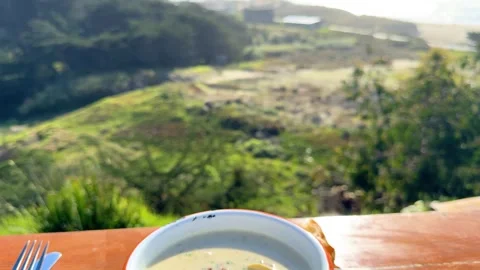 Close-Up of Chowder and Bread Bowl Overlooking the Coast Stock Footage 306251079