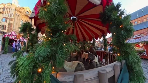 Close-up of a Christmas carousel under a red-and-white canopy with pine Stock Footage 327332366