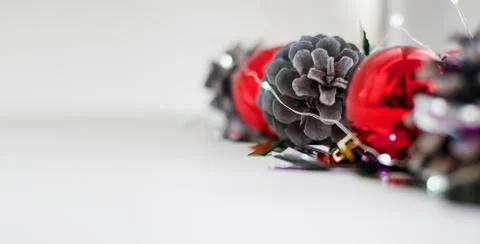 Close-up Christmas composition of balls, pine cones and garlands on a white b Stock Photos