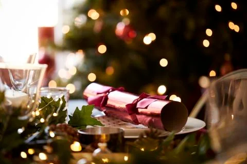 Close up of Christmas table setting with a Christmas cracker arranged on a pl 写真素材