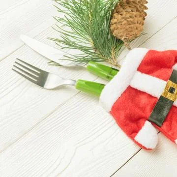 Close-up of Christmas table setting with fork, knife, green fir decor Stock Photos