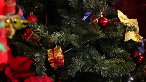 Close-up of a Christmas tree adorned with red balls, gold bows, purple ribb.. Stock Footage 320739230