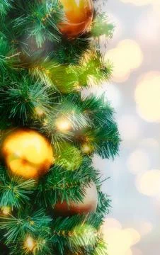 Close up of Christmas tree branches adorned with golden ornaments and twink.. 写真素材