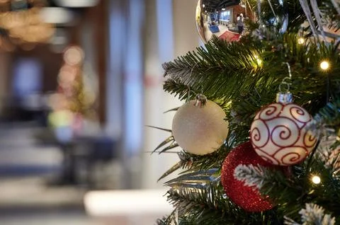 Close-up of Christmas tree branches decorated with glittery baubles and light Stock Photos