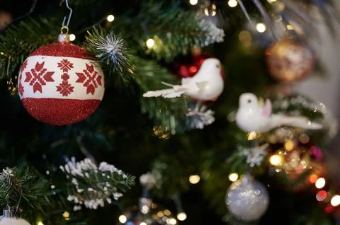 Close-up of Christmas tree branches decorated with white bird figurines, red  Stock Photos