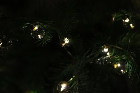 Close-Up of Christmas Tree Branches with String Lights and Glass Baubles Stock Photos
