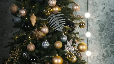 Close up of Christmas tree decorated with gold shiny balls, garland light Stock Footage 255813448