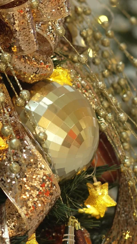 Close-up of Christmas tree with gold and red ornaments. The tree is illuminated Stock Footage 344905833