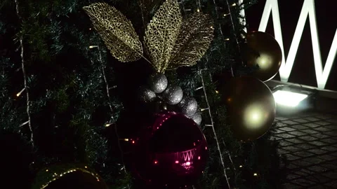 Close-up of Christmas tree ornaments with red and gold baubles, glitter leaves Stock Footage 340345182