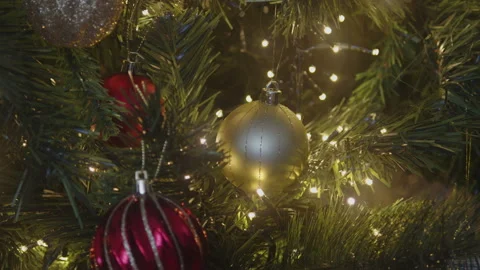 Close-up of Christmas tree ornaments with string lights 4K video Stock Footage 240874029