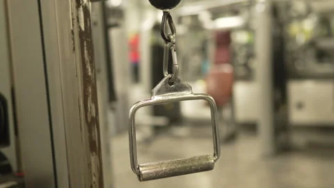 A close-up of a chrome-plated metal cable machine handle at gym Stock Footage 303586539