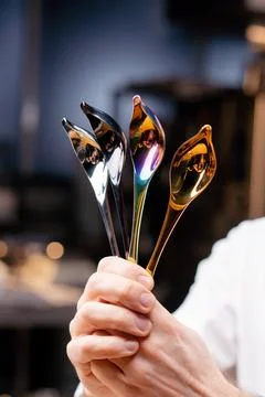 Close-up of chrome professional spoons of tools in the hands of a chef in Foto stock