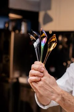 Close-up of chrome professional spoons of tools in the hands of a chef in 写真素材
