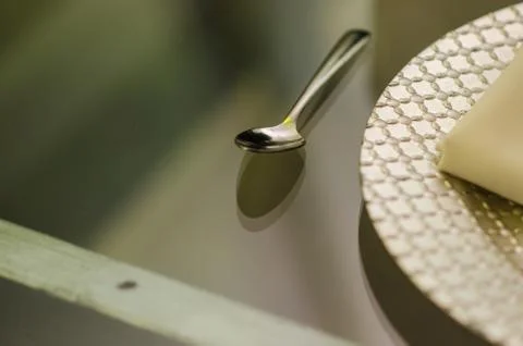 Close up of a chrome spoon with a silver plate on one side on a transparent g Stock Photos