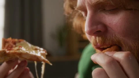 Close-up of Chubby Man with Beard Enjoying Cheesy Pizza with Fried Onion Ring Stockbeeldmateriaal 309204981