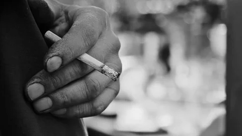 Close up cigarette stub in dirty hand. Black and white Stock Footage 83765055