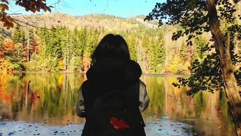 Close up cinematic back view caucasian woman hiker standing by lake taking ph 動画素材 163884091